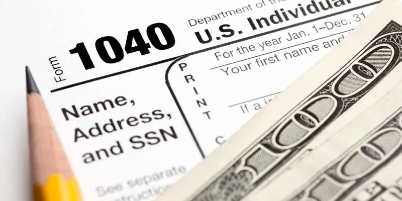 A tax return with pencil and money.