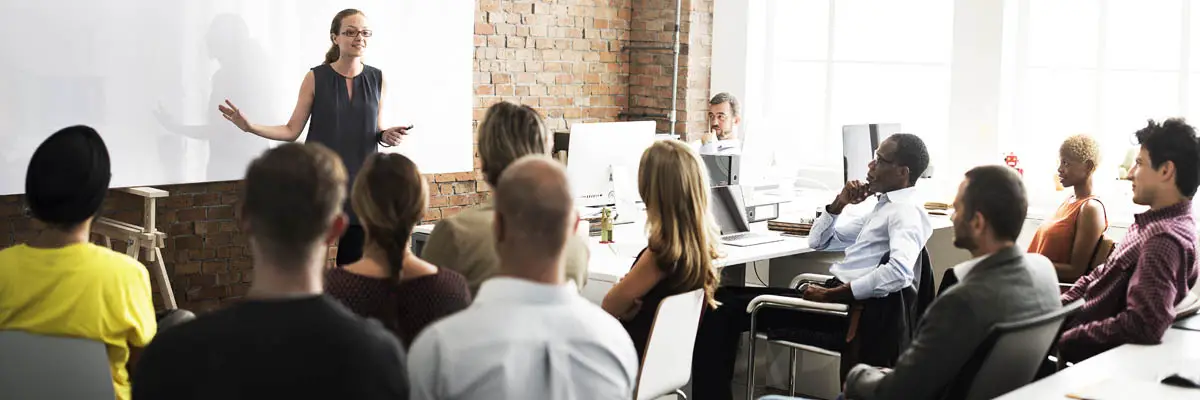 A person addressing of a group of people in an office.