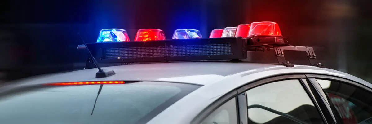 a police car with flashing red and blue lights.