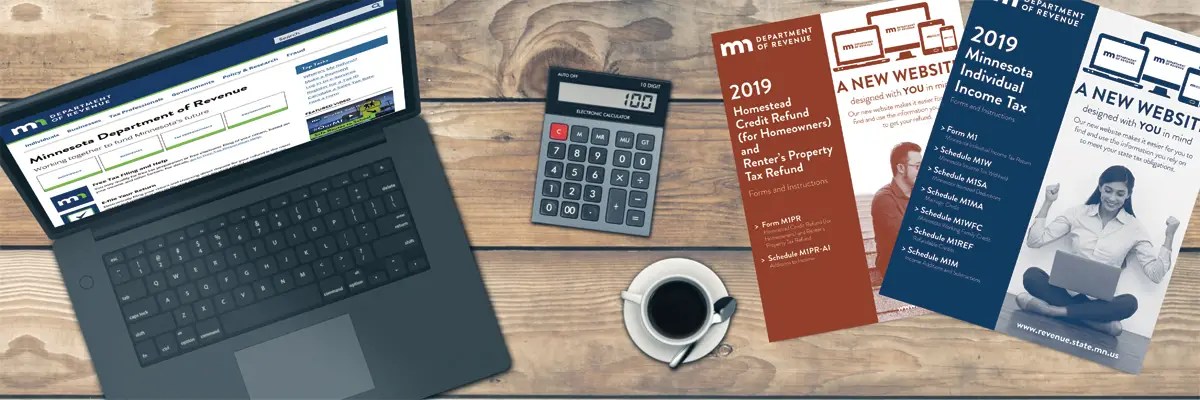 A laptop showing the Minnesota Department of Revenue's website on a table next to a calculator.