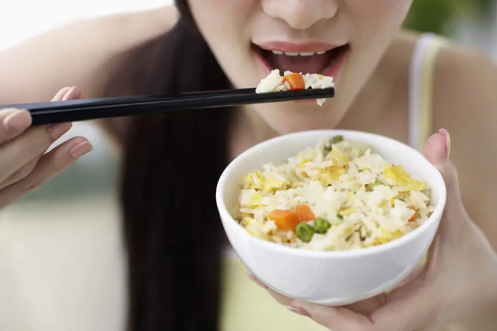 using chopsticks to eat rice